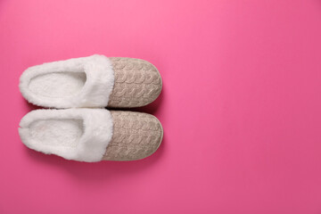 Pair of beautiful soft slippers on pink background, top view. Space for text