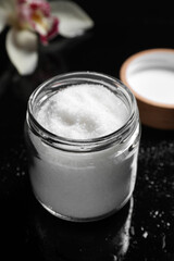 Jar with natural sea salt on mirror table