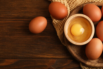 Raw chicken eggs on wooden table, flat lay. Space for text