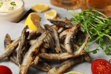 Delicious fried anchovies, microgreens and tomatoes, closeup view