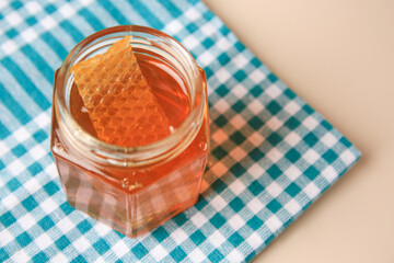 Jar with honey and combs on light table, space for text