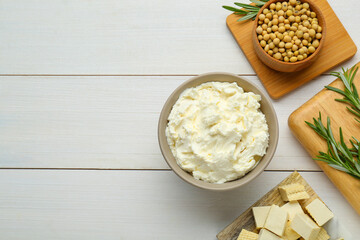 Delicious tofu cheese, soy beans and rosemary on white wooden table, flat lay. Space for text