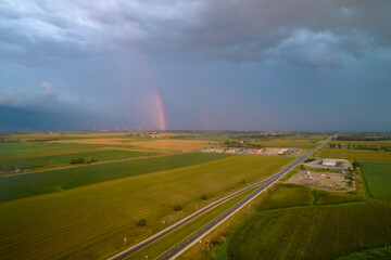 Naklejka na ściany i meble Aerial view of landscape after rain, rainbow in clouds