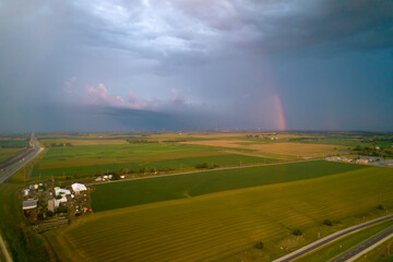 Naklejka na ściany i meble Aerial view of landscape after rain, rainbow in clouds