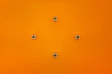 外向きに四方向いている矢印のウッドキューブのオレンジの背景