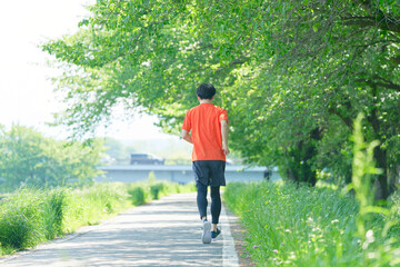 屋外でランニングする男性　全身　後ろ姿