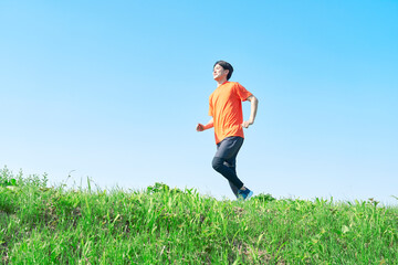  屋外でランニングする男性　コピースペースあり