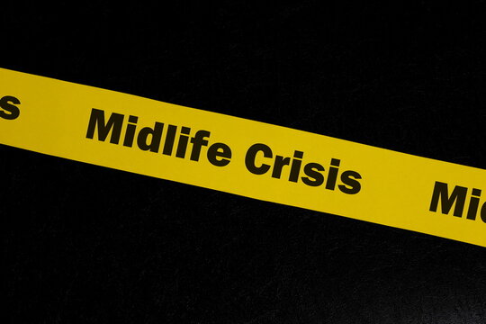 Midlife crisis caution and warning concept. Yellow barricade tape with word midlife crisis in dark black background.