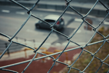 철조망 밖의 흐린 풍경으로 지나가는 자동차