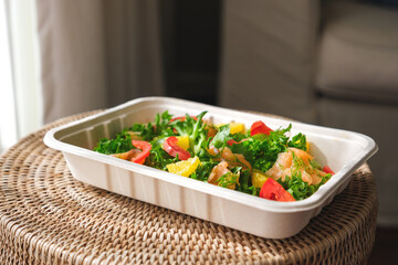 A fresh salmon salad in paper box for takeaway food