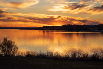 The golden light reflects off of the sky and the water at the end of a perfect day. as the sunsets...