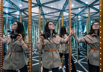 Woman with camera in mirror maze