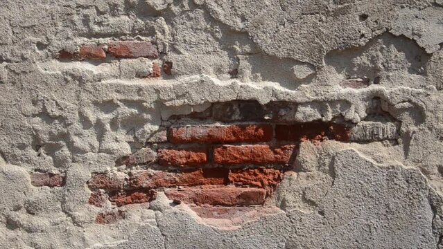 Old brick wall with peeling cement, Caused by an earthquake or a state of disrepair.