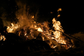 Bonfire burning in the snow at night