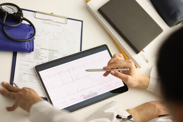 Doctor looks at ECG on tablet computer in cardiology center