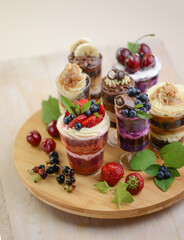 Homemade desserts in glass jars. Traditional unbaked Italian dessert on a white background. Cake with coffee, berries, fruits and mascarpone cream.