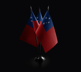 Small national flags of the Samoa on a black background