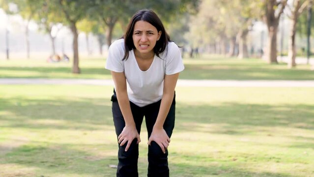Indian woman taking long breaths after a workout