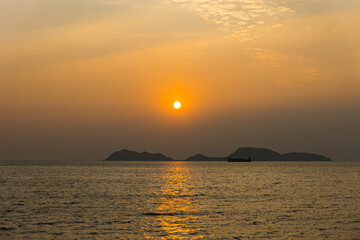Naklejka na ściany i meble warm orange sunset over the sea, ocean and beach