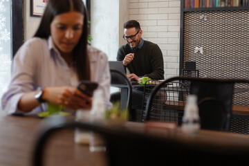 Businessman having coffee and doing his work in cafe. (Back focus)