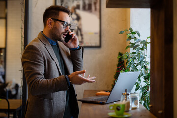 Young businessman talking on the phone in the cafe