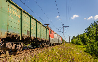 An electric locomotive with cars rides on rails.Railway train.