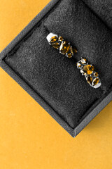 Earrings in a box on yellow