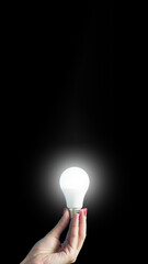 lamp in a woman's hand. female fingers holding LED lamp. idea. New idea or inspiration concept. Concept of startup. Vertical image.