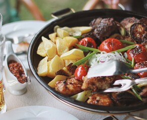 delicious frying pan with vegetables and meat. Potatoes, tomatoes and hot sauce. top view, flatly