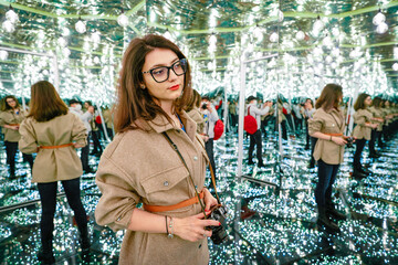 Woman with camera in mirror maze