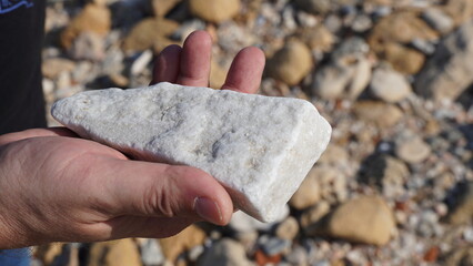 2000 years old piece of white marble in archeologist hand. Caesarea Maritima National Park