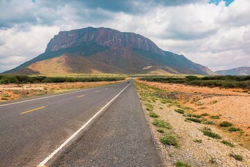 An empty highway against the background of Mount Ololokwe in Masabit County, Kenya