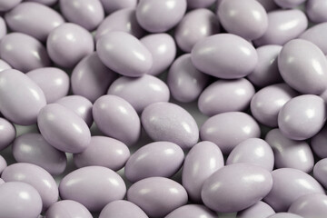 Chocolate dragee in the form of a pile. White chocolate dragee covered with sugar on the outside and filled with chocolate on the inside. close up