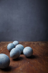Fototapeta na wymiar Blue diy painted easter eggs on brown wooden rustic table, grey background. Vertical shot, copy space