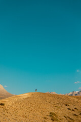 Fototapeta na wymiar Hiking in the mountains. The girl is walking along a mountain path.