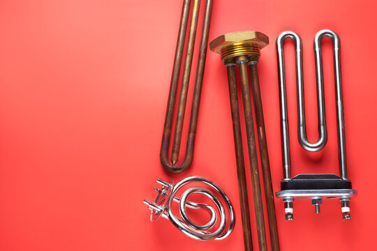 Set of different types Tubular electric Heating elements made of steel for washing machines, boiling water, heating, isolated on red background