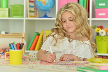 girl drawing picture at desk at home
