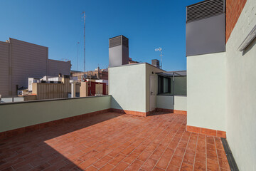 An empty spacious terrace on a roof of a large house with tiled red floor for relaxing on warm...