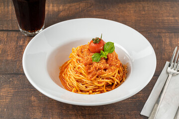 Pasta with cheese and tomato sauce on a white porcelain plate