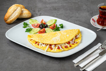 Omelet with feta cheese and Turkish sausage on a white porcelain plate