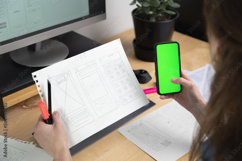 Sticker sketch of wireframe for website. women designer working on a mobile application, drawing on paper.