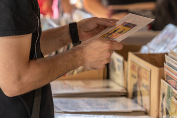 Selective focus on the right hand of an unrecognizable man at a flea market looking for vinyl...