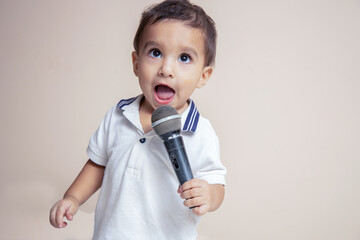 Indian cute little baby toddler holding mic in hand and singing. Playful Child.