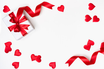 Gift box with red ribbon and hearts on white background
