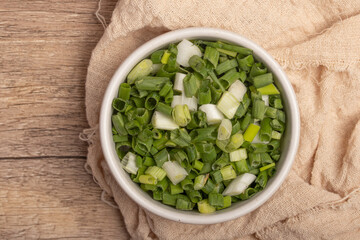 Sliced spring onions in a white cup