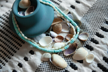 Coral and coconut beads  on pattern towel with clay pottery close up 