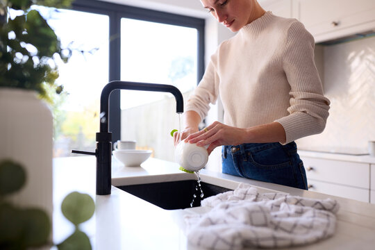 Close Up Of Woman At Home In Kitchen Doing Washing Up