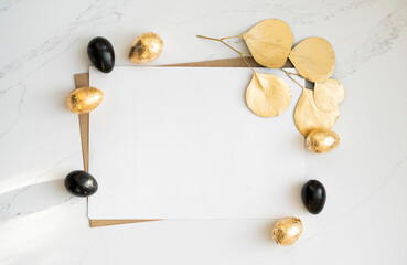 Mockup, Easter golden and black eggs with golden eucalyptus leaves.