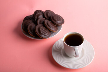 photo round sweets on a plate and a cup with a drink on a saucer