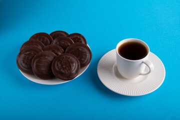 photo chocolate chip cookies on a white plate and a cup of tea on a saucer
